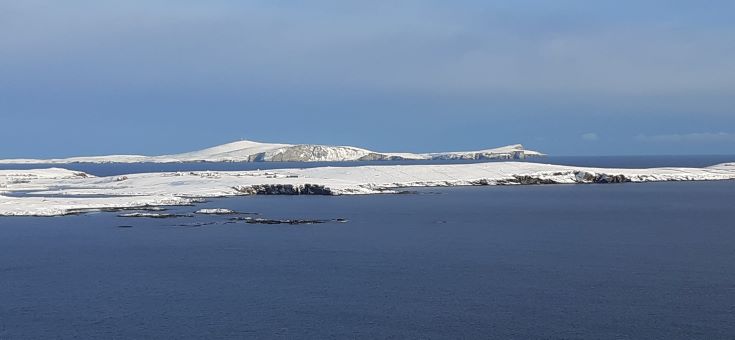 A view of snow covered Islands across the sea from the mainland