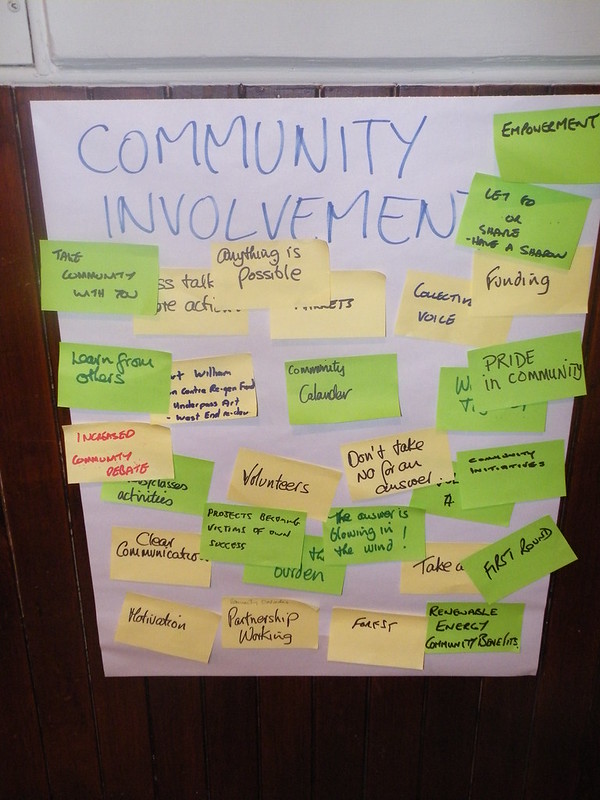 Flip chart headed up "community involvement" with yellow and green post-it notes