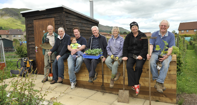 People sitting on wall in allotment