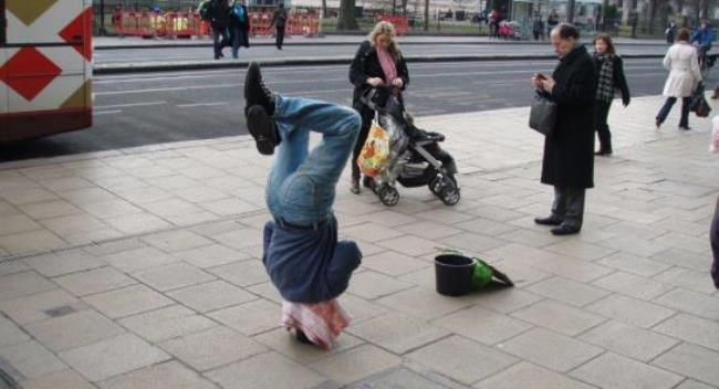 Man doing headstand in street