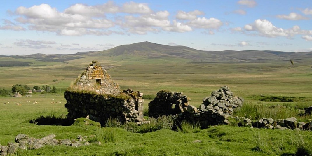 Ruined stone building amongst grass and hills