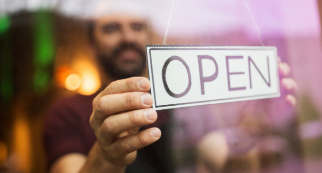 Man putting open sign in window