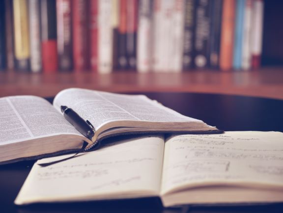 a writers book with a pen on a table