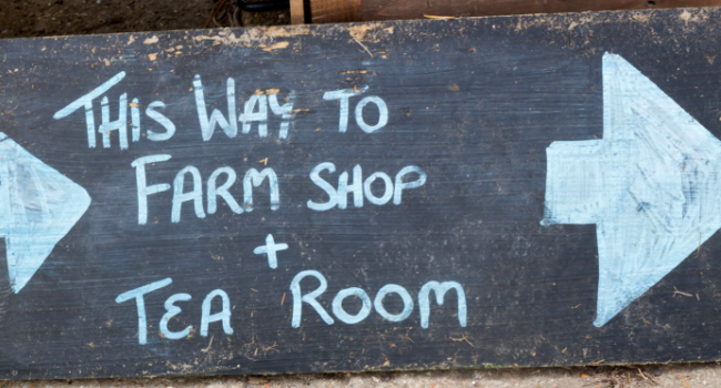 Chalkboard sign 'This way to farm shop and tea room'