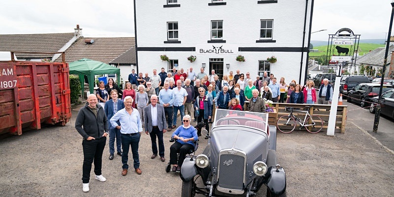 Group of around forty people in front of a pub