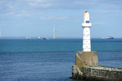 Lighthouse with wind turbines at sea