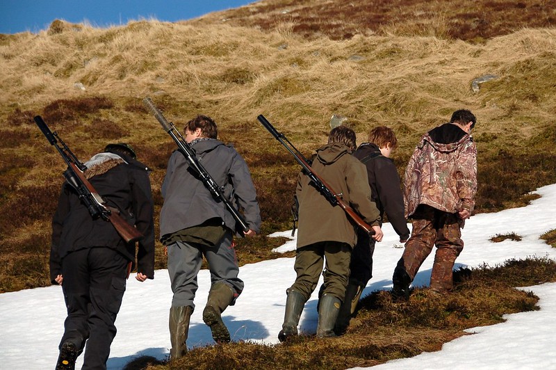 Group of people with shotguns in the Scottish countryside