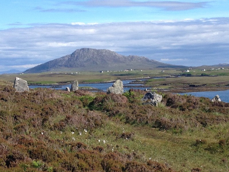 Standing stones on hill overlooking loch and mountain