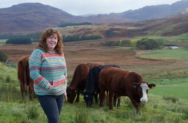 Crofter Fiona MacDonald with cows and hills in the background