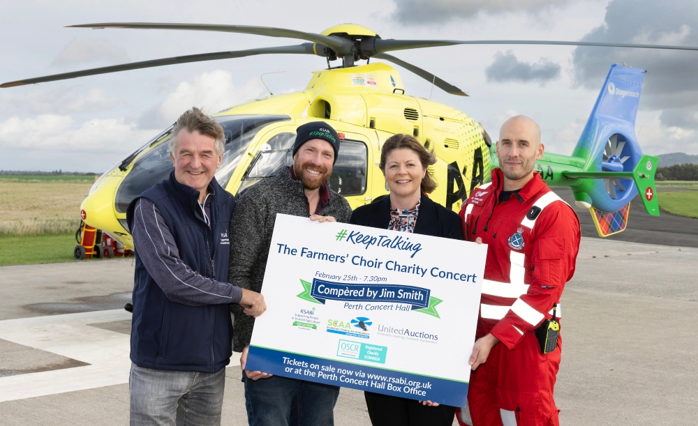 Four people in from of Air Ambulance promoting RSABI farmers choir concert