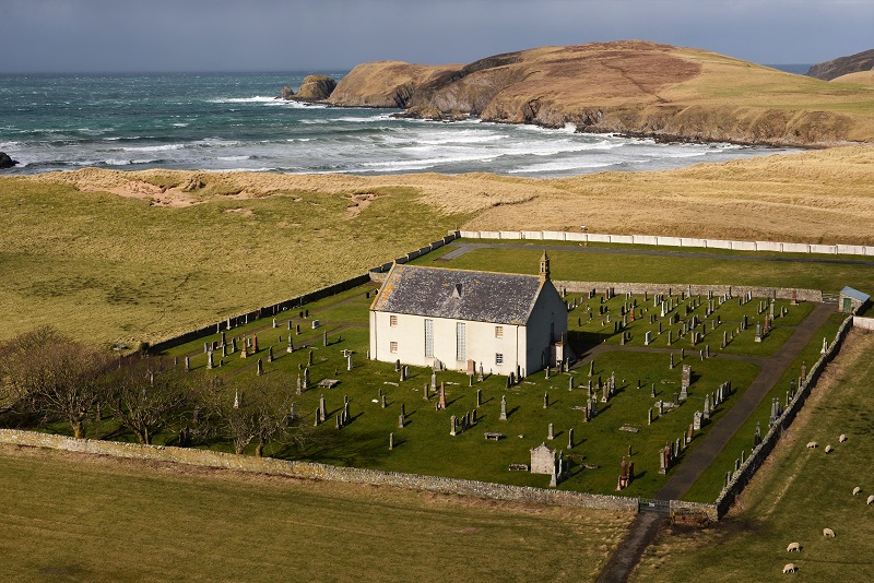 Church and churchyard with sea and cliffs