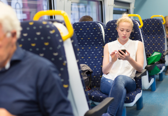 Woman looking at mobile phone on train