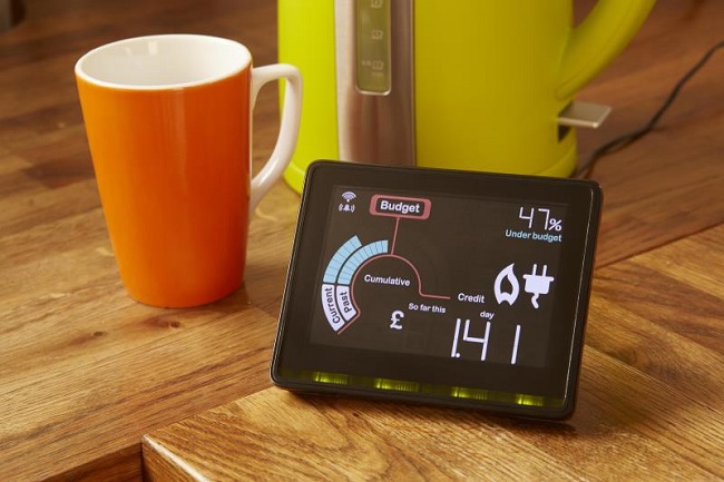 Photo with smart meter, mug and kettle on kitchen table