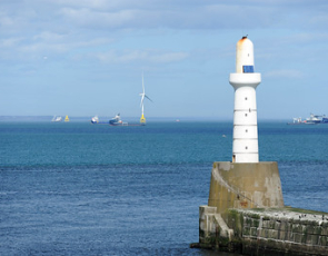 Lighthouse with wind turbines at sea