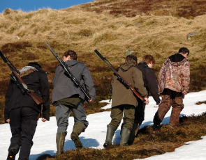 Group of people with shotguns in the Scottish countryside