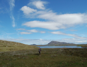 Walker with backdrop of sea loch and hill