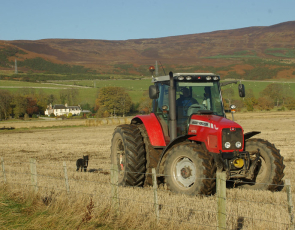 Farmer in tractor preparing field for ploughing