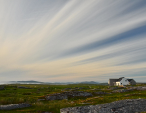 View of open country in North Uist with house in the distance