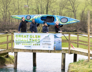 Alasdair Forsyth, Solicitor in Land and Rural Business at Gillespie Macandrew, Harry Seran, Head of Finance and Compliance at RSABI, Carol McLaren, RSABI Chief Executive and Lois Newton, Partner of Land and Rural Business at Gillespie Macandrew holding a canoe while standing on a footbridge 