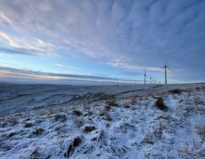 Winter view over snow covered moorland with wind turbines on the horizon