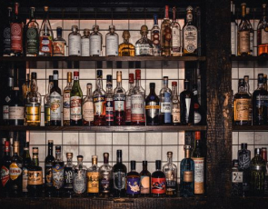 Shelves of alcohol behind a bar