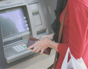 young woman using cash machine