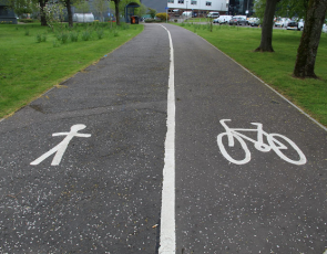 Cycle path divided by thick white line with image of stick person on one side and a bike on the other