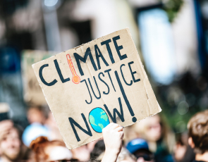 Banner with Climate Justice Now at demo - picture credit, Markus Spiske via Pixlr. 