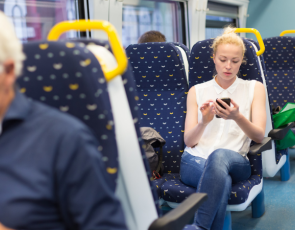 Woman looking at mobile phone on train