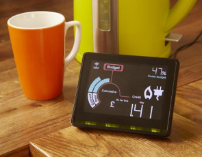 Photo with smart meter, mug and kettle on kitchen table