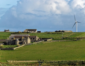 farms and wind turbine on a hill