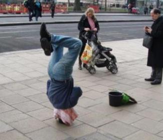 Man doing headstand in street