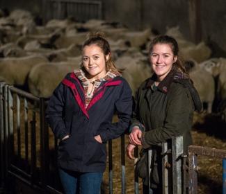 Sisters Kirsty and Aimee Budge standing in front of sheep
