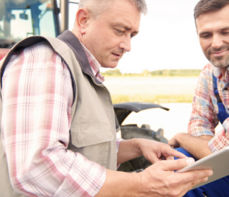 Two farmers looking at tablet