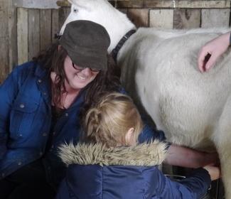 Kat Goldin and vistiro Niamh milking a goat at Gartur Stitch Farm