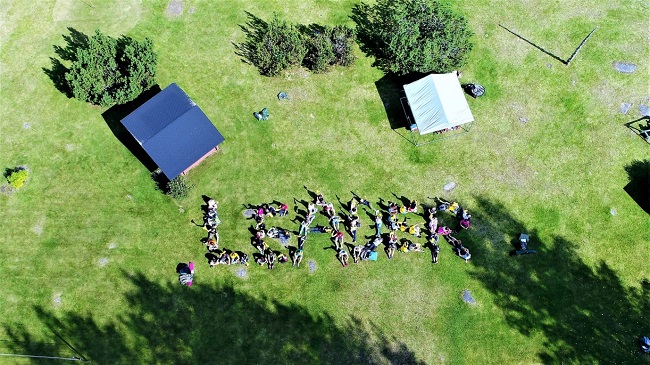 Aerial view of people standing to make the word LEADER
