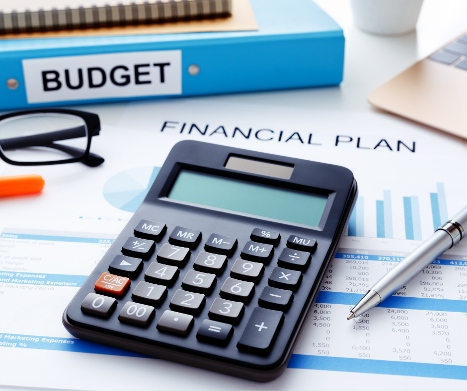 calculator on a desk with spreadsheet and folder titled "budget".