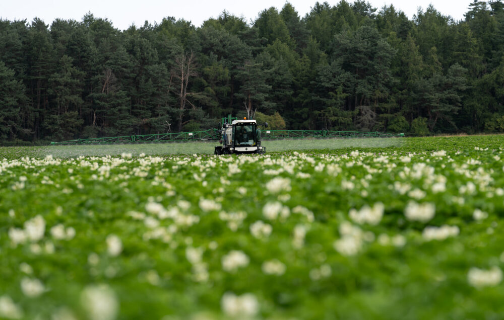 Farm machinery spray crops on a Scottish farm