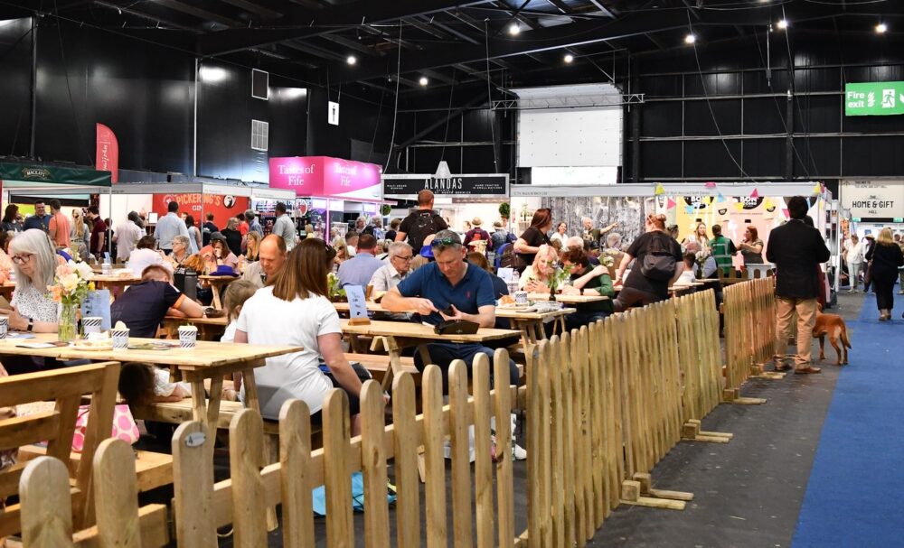 People eating in a large hall at an agriculture show