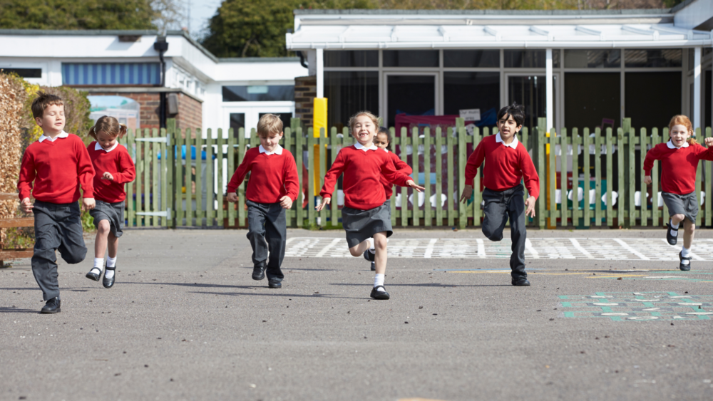 Elementary School Pupils Running in Playground