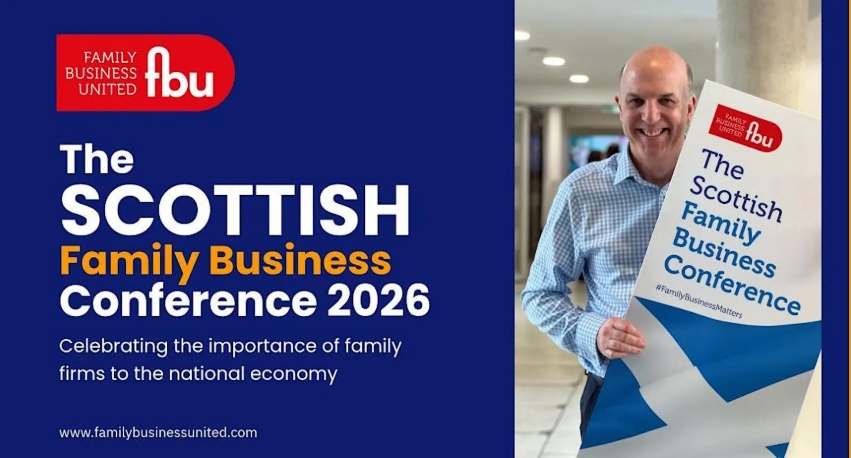 Smiling man holding a sign for The Scottish Family Business Conference 2026 in a modern indoor setting.