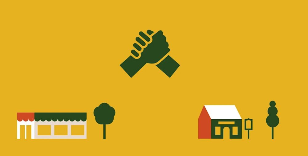 Two hands clasped in a handshake above two stylised buildings separated by trees on a mustard yellow backgrounds