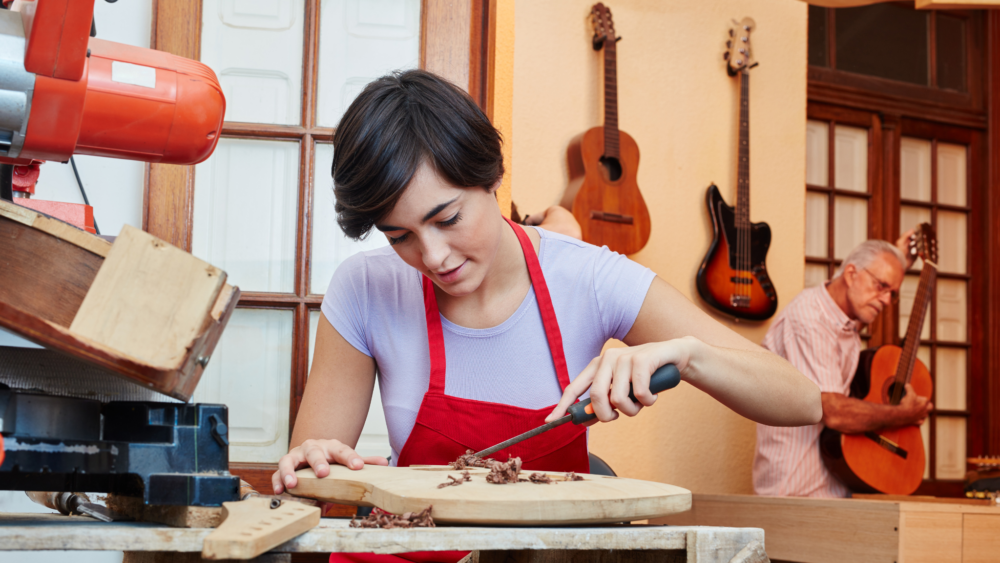 Woman Carpenter in guitar workshop.